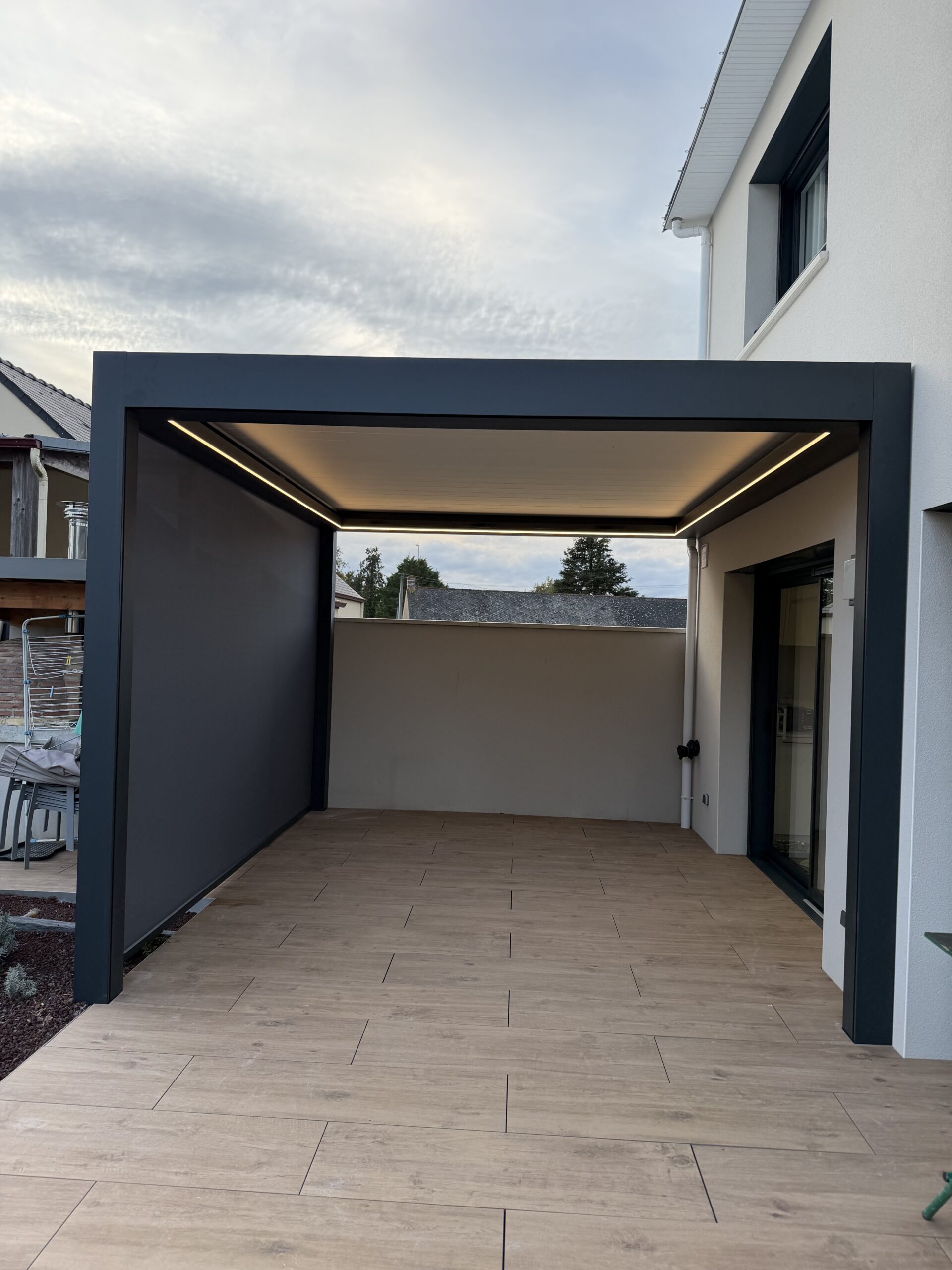 Pergola moderne avec éclairage intégré et sol en bois.